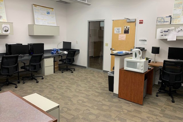 Computer lab with desk space, computers, and chairs.
