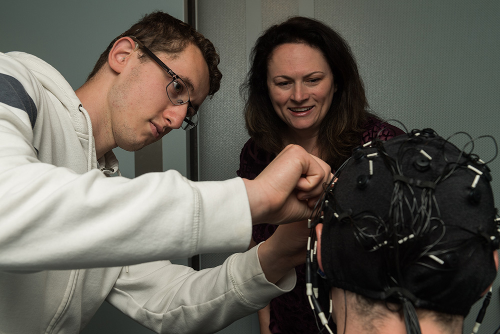 Dr. Houston supervising student using EEG equipment