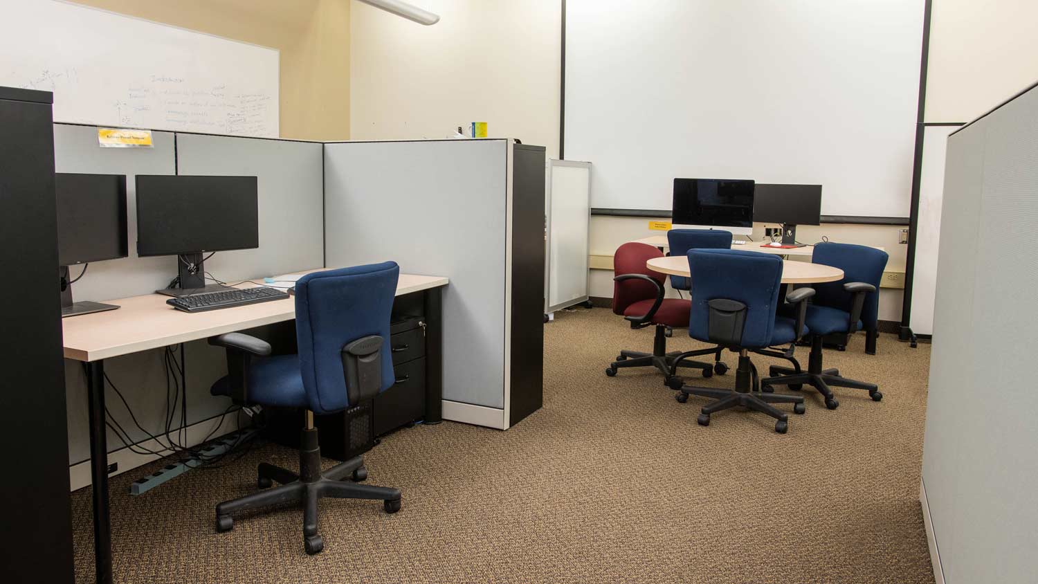 Cubicles with computer workstations and a small round table