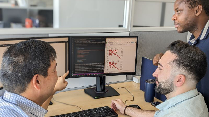 Professor Yang pointing to a computer screen with code on it.